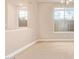 Bright bedroom with natural light from large windows, neutral carpeting, and view to ensuite bathroom at 263 W Rosemary Dr, Chandler, AZ 85248