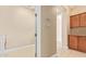 The laundry room has tan tile floors, wooden cabinets, and leads to other rooms at 263 W Rosemary Dr, Chandler, AZ 85248