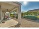 Covered patio with seating area, mature landscaping, and gravel at 26335 W Burnett Rd, Buckeye, AZ 85396