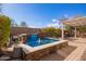 Inviting backyard oasis featuring a built-in pool with a water fountain and pergola at 2927 W Plum Hollow Dr, Anthem, AZ 85086