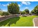 Picture of backyard showcasing a lush green lawn and beautiful desert landscaping with trees at 300 N Portland Ave, Gilbert, AZ 85234