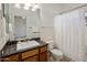 Well-lit bathroom with dark wood cabinets, tile floors, and a shower/tub combo at 300 N Portland Ave, Gilbert, AZ 85234