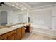 Large bathroom featuring dual sinks, granite countertops, and a soaking tub at 300 N Portland Ave, Gilbert, AZ 85234
