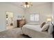 Bedroom featuring a soft rug, neutral walls, queen bed, and view to an ensuite bathroom at 300 N Portland Ave, Gilbert, AZ 85234