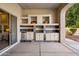 Outdoor kitchen features cabinets, tile backsplash, sink, mini fridge, and plenty of counter space at 300 N Portland Ave, Gilbert, AZ 85234