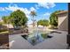 Backyard pool with stone waterfalls, lush landscaping, outdoor grill, and tile surround at 300 N Portland Ave, Gilbert, AZ 85234