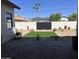 Landscaped backyard featuring a small lawn, desert plants, brick pavers and a tall privacy fence with black wooden gate at 3021 N 47Th St, Phoenix, AZ 85018