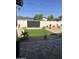 Cozy backyard with artificial turf, desert landscaping, a paved patio and a privacy wall with a black wooden gate at 3021 N 47Th St, Phoenix, AZ 85018