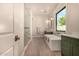 Bright bathroom with a glass-enclosed shower and a soaking tub near a large window at 3021 N 47Th St, Phoenix, AZ 85018