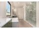 Bright bathroom featuring a soaking tub, a glass shower, and dual sinks with modern fixtures and hardwood floors at 3021 N 47Th St, Phoenix, AZ 85018