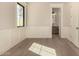 Empty bedroom with hardwood floors, wainscoting and a view to an adjacent bathroom at 3021 N 47Th St, Phoenix, AZ 85018