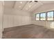 Light-filled bedroom with hardwood floors, paneled accent wall, and expansive windows offering natural light at 3021 N 47Th St, Phoenix, AZ 85018