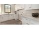 Well-organized laundry room with white cabinetry, modern countertops, and wood-look flooring at 3021 N 47Th St, Phoenix, AZ 85018