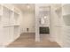 Bright walk-in closet leading to a bathroom, featuring custom shelving and hardwood floors, offering an organized space at 3021 N 47Th St, Phoenix, AZ 85018