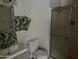 Bathroom with a toilet, sink, shower, and tropical-themed decor at 3120 N 67Th Ln # 42, Phoenix, AZ 85033