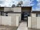 Front view of a tan, two-story condo with a walkway and patterned block wall at 3120 N 67Th Ln # 42, Phoenix, AZ 85033
