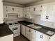 White kitchen cabinets, dark countertops, and electric range at 3120 N 67Th Ln # 42, Phoenix, AZ 85033