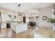 Bright kitchen featuring an island, white cabinetry, granite countertops, and an adjacent dining area at 4361 S Slow Pony Cir, Gold Canyon, AZ 85118