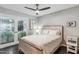 Bright bedroom with a queen bed, stained glass doors, and ceiling fan at 4809 N 78Th Pl, Scottsdale, AZ 85251