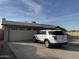 Tan house with a two-car garage and a driveway, set against a clear sky at 4830 S 22Nd Pl, Phoenix, AZ 85040