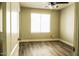 Simple bedroom with wood-look floors and large window at 7 N 87Th Dr, Tolleson, AZ 85353