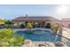 Stunning backyard pool with rock waterfall feature, surrounded by palm trees and lush landscaping at 7278 E La Junta Rd, Scottsdale, AZ 85255