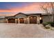 Three-car garage with brown wooden doors and stone facade at 8124 E Paraiso Dr, Scottsdale, AZ 85255