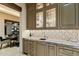 Custom wet bar with granite countertops and glass-front cabinetry at 8124 E Paraiso Dr, Scottsdale, AZ 85255