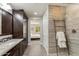 Bathroom featuring a granite vanity, tiled shower, wood cabinets, and an open doorway into the bedroom at 10260 E White Feather Ln # 1038, Scottsdale, AZ 85262