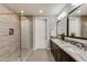 Bathroom featuring a dual sink vanity with granite countertops, and a glass-enclosed shower at 10260 E White Feather Ln # 1038, Scottsdale, AZ 85262