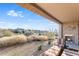 Inviting covered patio with a fireplace and lounge seating, overlooking the natural desert landscape at 10260 E White Feather Ln # 1038, Scottsdale, AZ 85262