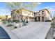 Beautiful home featuring a stone facade and a three-car garage, complemented by desert landscaping at 10260 E White Feather Ln # 1038, Scottsdale, AZ 85262