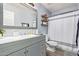 Modern bathroom with gray vanity, white shower curtain, and a large mirror at 11830 W Avenida Del Sol --, Sun City, AZ 85373