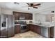 Modern kitchen with dark wood cabinets, granite countertops, and stainless steel appliances at 1195 E Dust Devil Dr, San Tan Valley, AZ 85143