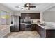 Modern kitchen with dark wood cabinets, granite countertops, and stainless steel appliances at 1195 E Dust Devil Dr, San Tan Valley, AZ 85143