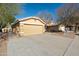 House exterior showcasing a two-car garage and a well-maintained front yard at 12000 W Bloomfield Rd, El Mirage, AZ 85335