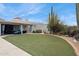 Landscaped backyard with grassy area and patio at 12210 N 76Th Pl, Scottsdale, AZ 85260