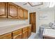 Laundry room with wood cabinets and built-in sink at 12210 N 76Th Pl, Scottsdale, AZ 85260