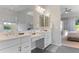 Bright bathroom featuring double sinks, white cabinets, and a large vanity area at 12349 N 145Th Ave, Surprise, AZ 85379