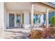 Covered front porch with a seating area, potted plants, and a decorative wreath on the front door at 12349 N 145Th Ave, Surprise, AZ 85379