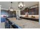 Kitchen island with granite countertops, dark cabinets, and pendant lighting at 1238 W Silver Creek Ln, San Tan Valley, AZ 85140