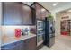 Modern kitchen with dark cabinetry, granite countertops, and stainless steel appliances at 1238 W Silver Creek Ln, San Tan Valley, AZ 85140