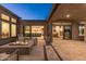 Entertainer's backyard patio with an outdoor fireplace, comfy seating, and easy access to indoor dining and kitchen areas at 13238 E Ranch Gate Rd, Scottsdale, AZ 85255