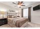 Well-lit bedroom featuring a ceiling fan and stylish decor at 14805 W Caribbean Ln, Surprise, AZ 85379