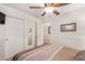 Bright bedroom with mirrored closet doors and ceiling fan at 14805 W Caribbean Ln, Surprise, AZ 85379