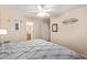 Main bedroom with gray bedding and ceiling fan at 14805 W Caribbean Ln, Surprise, AZ 85379