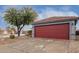 House exterior with red garage door and neatly kept desert landscaping at 14805 W Caribbean Ln, Surprise, AZ 85379