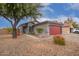 One-story home with gray exterior, red garage door, and desert landscaping at 14805 W Caribbean Ln, Surprise, AZ 85379