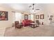 Bright living room featuring a red couch and ceiling fan at 14805 W Caribbean Ln, Surprise, AZ 85379