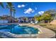 Relaxing backyard with a pool, patio furniture, and palm trees at 14905 W Dovestar Dr, Surprise, AZ 85374